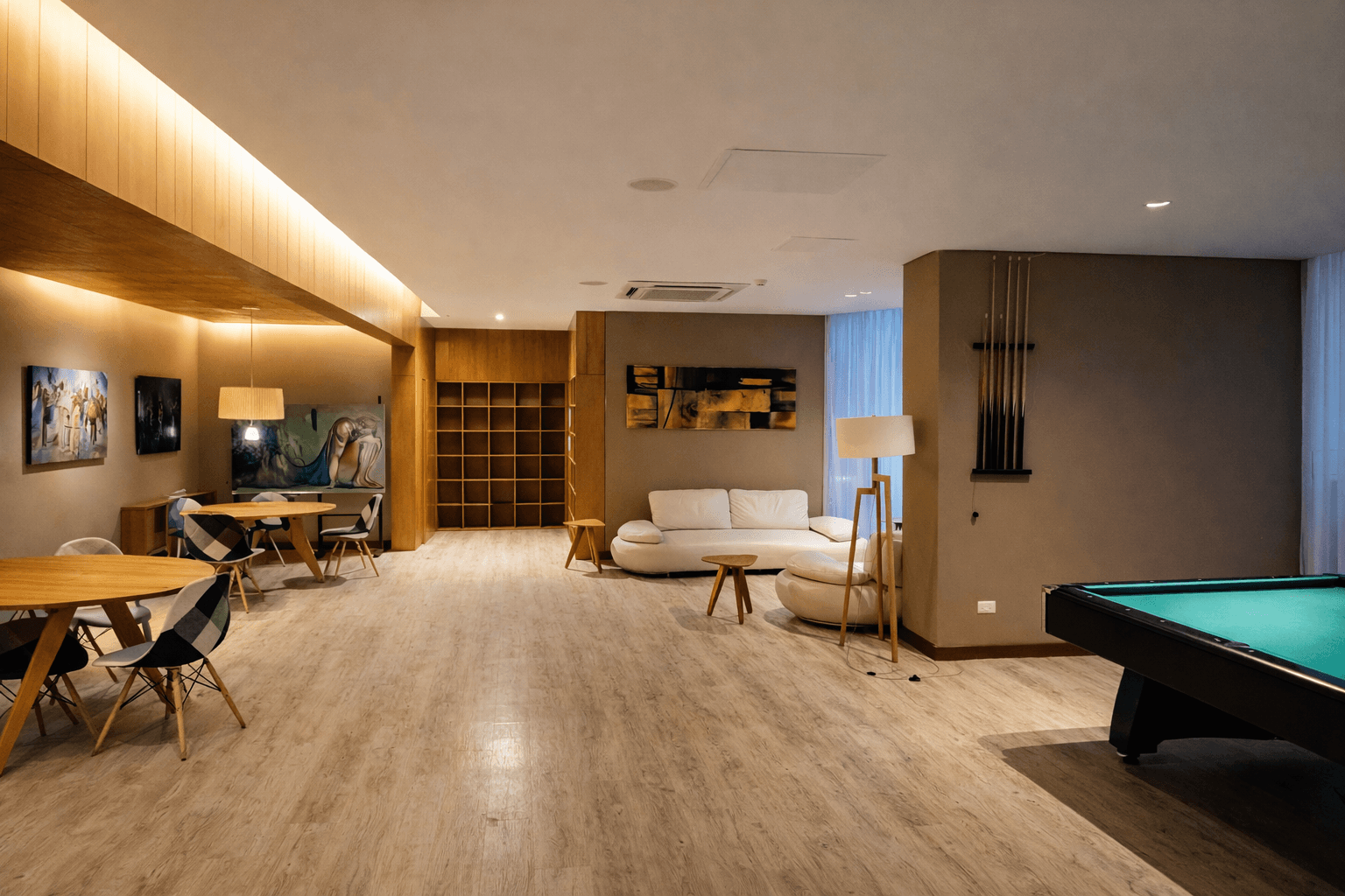 Amplio salón de juegos y espacio social del edificio, equipado con mesa de pool, áreas de estar y mesas para compartir.