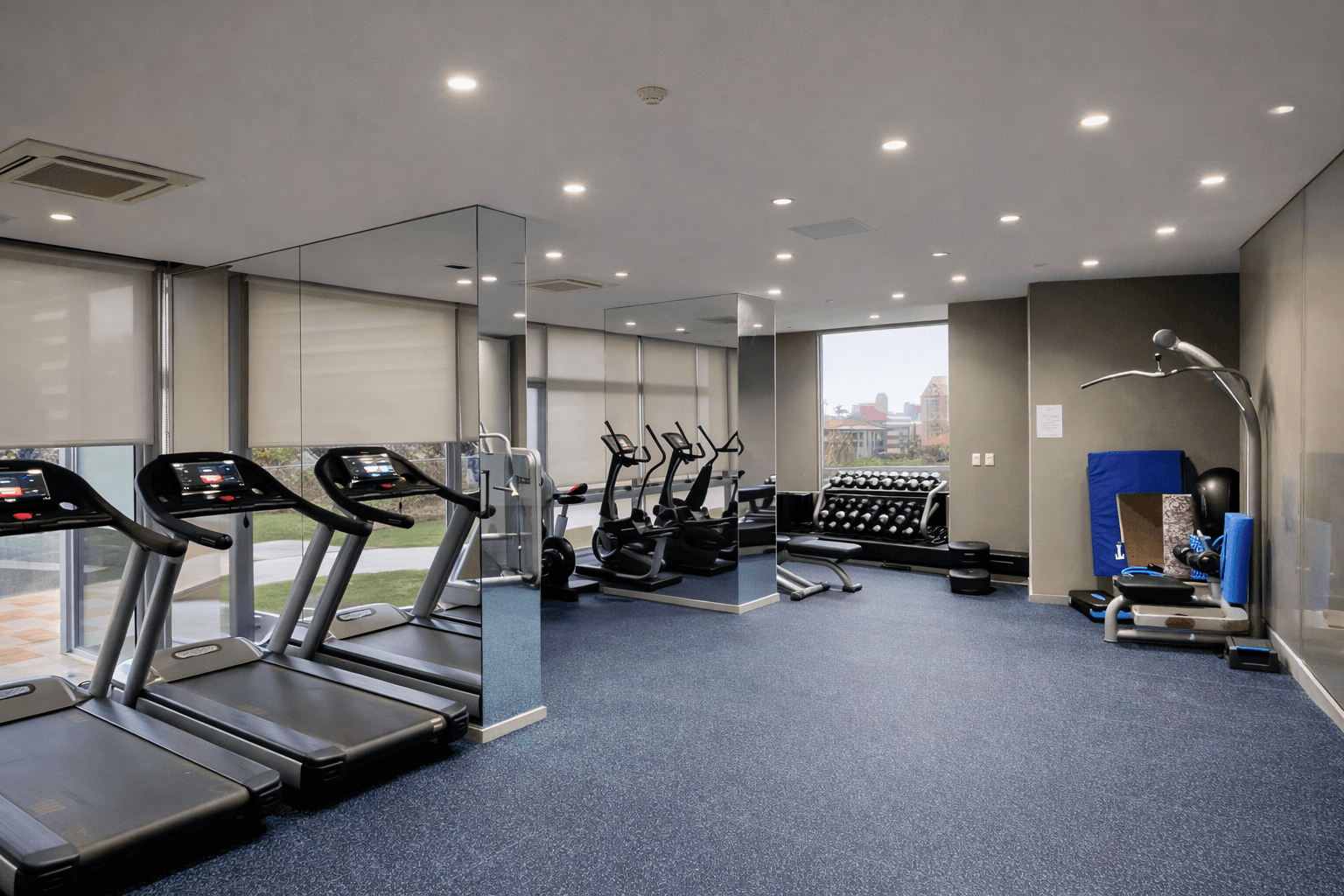 Gimnasio completamente equipado con cintas de correr, bicicletas, elípticos, pesas y equipos de musculación.